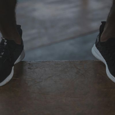 Close-up of athletic shoes on a dark floor, ready for movement.